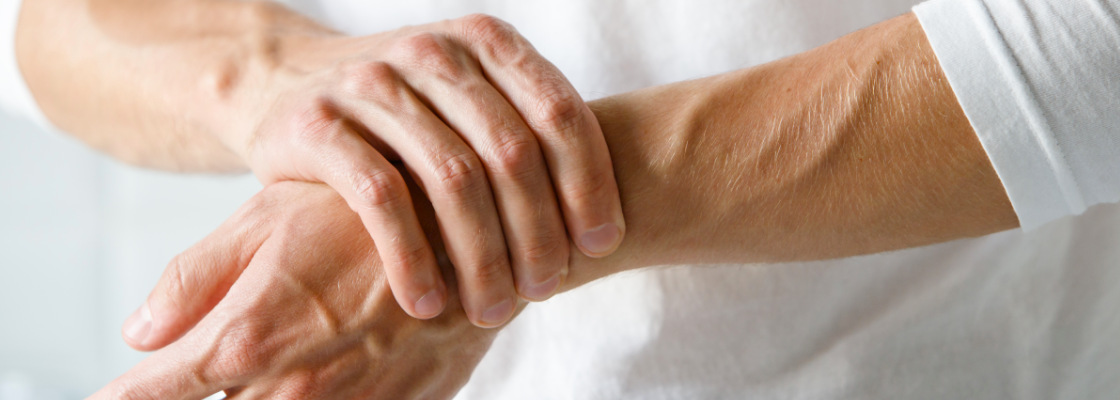 Holding own wrist in pain due to rheumatoid arthritis joint pain