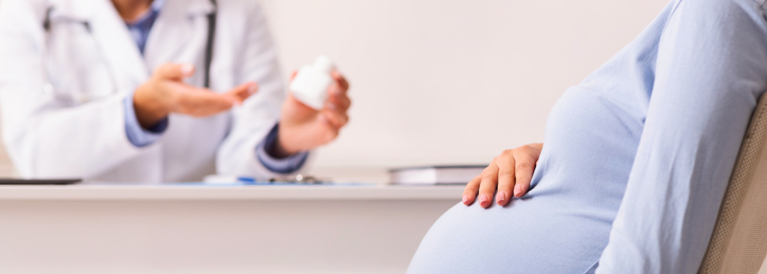 Pregnant woman at a doctor's office, with a healthcare professional explaining the importance of prenatal care and taking care of one's health during pregnancy