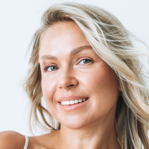 Closeup of a mature woman's face, close up, smiling with blond hair