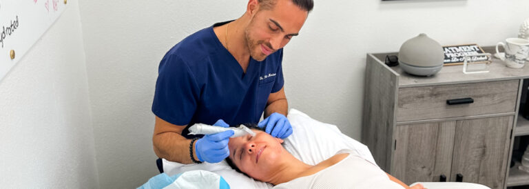 Dr. Pedi performing a micro-needling facial treatment on a patient