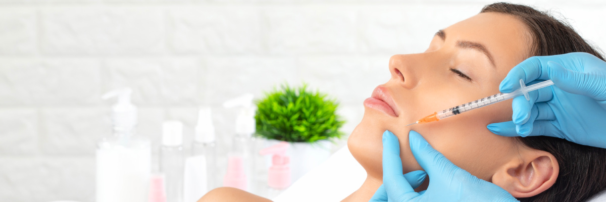 Woman laying down in clinic receiving a PPR facial needle to her cheek