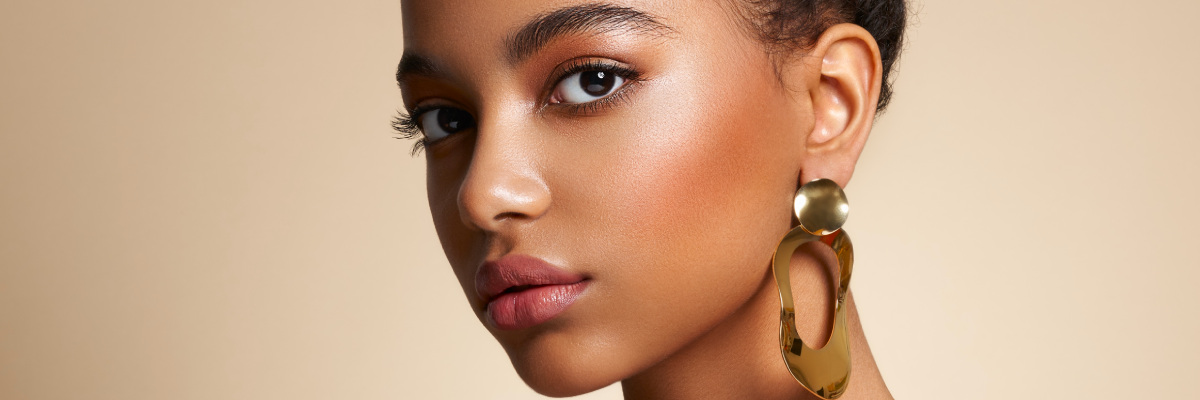 Close up of a woman's face portrait, in-front of a light brown backdrop