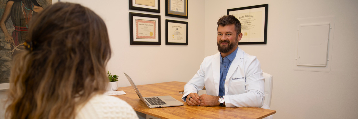 Dr. Dan Sullivan discussing with a patient at the Oasis Health and Medicine health clinic office