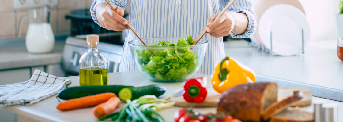 Woman mixing vegetables in bowl in a kitchen