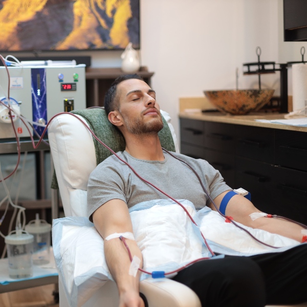Man with eyes closed receiving EBOO therapy